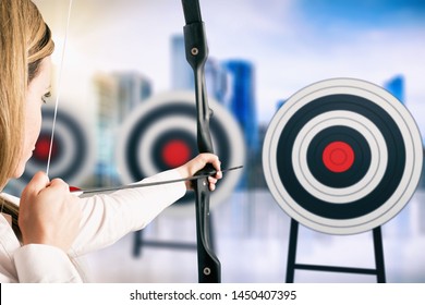 Businesswoman With Bow And Arrow Pointing The Center Of The Target