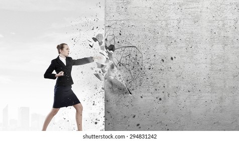 Businesswoman Breaking Stone Wall With Karate Punch