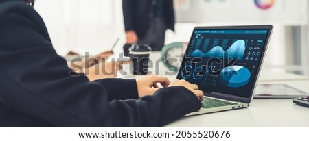 Businesswoman in business meeting using laptop computer proficiently at office for marketing data analysis . Corporate business team collaboration concept .
