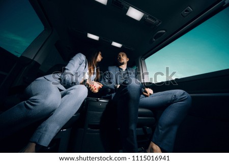 Businesswoman and businessman at the backseat of luxury vip shuttle 