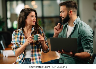 Businesswoman And Businessman Drinking Coffe In Office. Young Man And Woman Having Coffee Break.