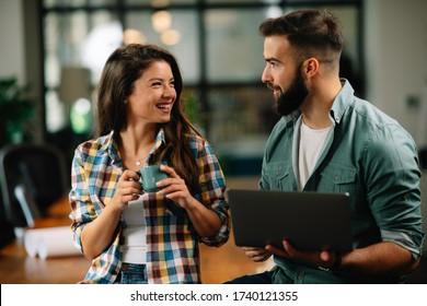 Businesswoman And Businessman Drinking Coffe In Office. Young Man And Woman Having Coffee Break.