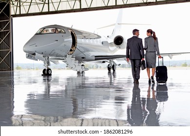 Businesswoman and Businessman walking towards a private jet