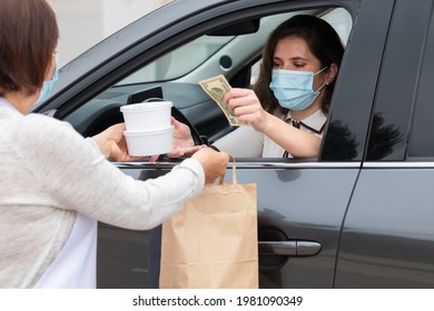 Businesswoman In A Car Buying Takeaway Food And Paying For It