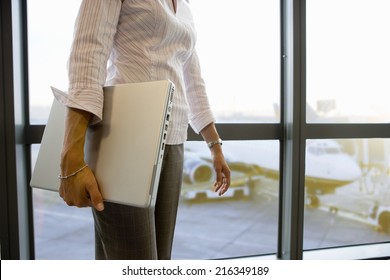 Businesswoman Carrying Laptop In Airport