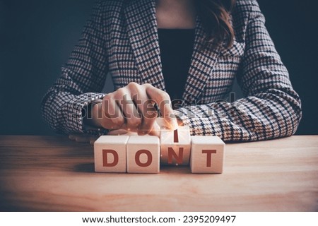 Businesswoman in checkered suit hand flipping wooden blocks between DONT to DOIT text. Don't or do it, dilemmas, personal development and career growth or change yourself concept. 