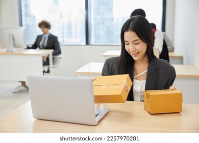 businesswoman checking parcel cardboard boxes from online shopping in the office - Shutterstock ID 2257970201