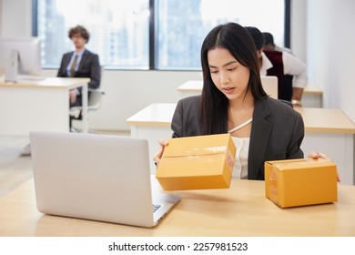 businesswoman checking parcel cardboard boxes from online shopping in the office - Shutterstock ID 2257981523