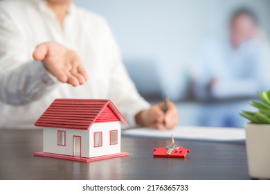 Businesswoman choosing mini house model from model on wood table, Planning to buy property. concept of Choose the best.