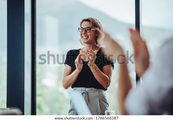 Businesswoman clapping hands after successful\
brainstorming session in boardroom. Business people women\
applauding after productive\
meeting.