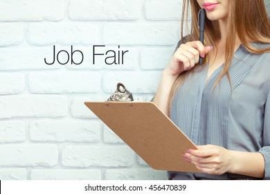 Businesswoman With Clipboard And Pen Making Notes And Standing Near Text - Job Fair