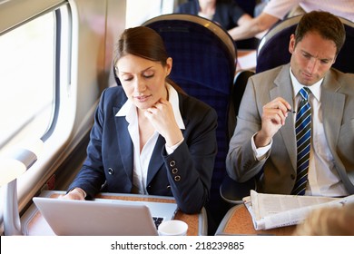 Businesswoman Commuting To Work On Train And Using Laptop