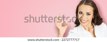 Businesswoman in confident cloth showing ok okay hand sign gesture, over blurred modern office background. Portrait of happy smiling gesturing business woman, isolated rose pink background.