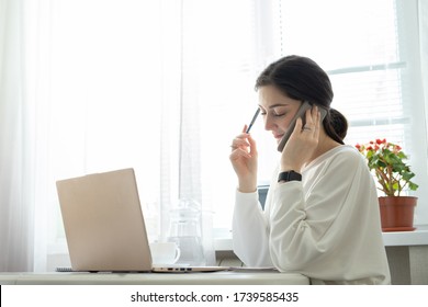 Businesswoman consults by phone from home. Talented manager remote working in laptop reading e-mail. Remote working and telephone consultations concept
