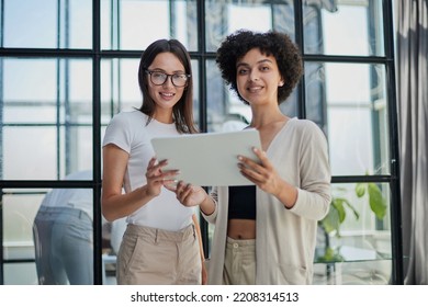 Businesswoman with coworker standing in modern office - Shutterstock ID 2208314513