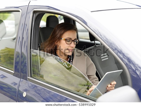 businesswoman with digital\
tablet in the car