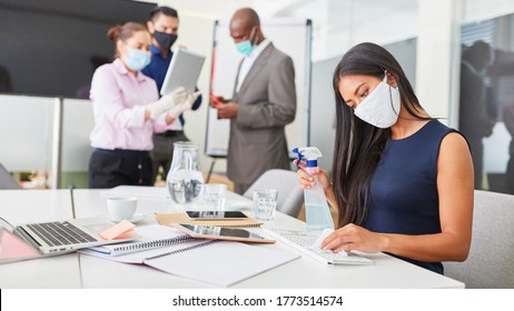 Businesswoman Disinfecting Face Mask At Work Because Of Covid-19 In Open Plan Office