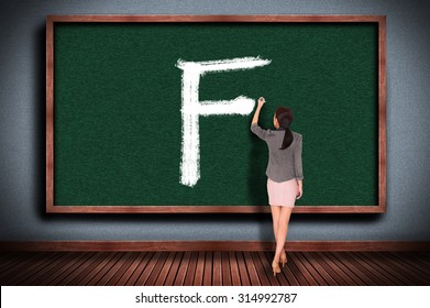 Businesswoman Drawing Grade F On Chalkboard