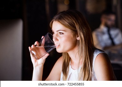 Businesswoman Drinking Water In Office At Night.