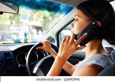 Businesswoman Driving Car And Talking On Cell Phone Concentrating On The Road