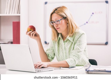 Businesswoman Is Eating Apple In Her Office.