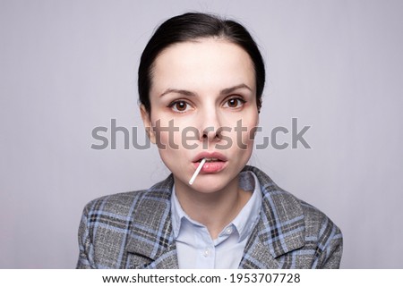 businesswoman eating lollipop, gray background