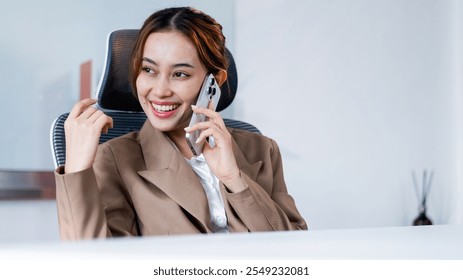 Businesswoman engaging in phone conversation modern office professional environment bright and inviting positive vibe - Powered by Shutterstock