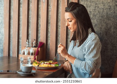 Businesswoman is enjoying a healthy lunch of salad and scrambled eggs during her break at a restaurant - Powered by Shutterstock