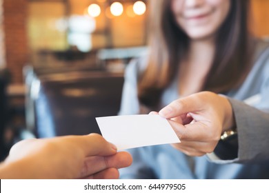 Businesswoman Exchange Business Card With Businessman In Coffee Shop