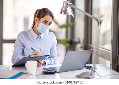 Businesswoman with face mask working in the office.