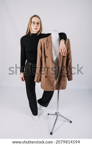 Businesswoman, fashion designer, stylist. Full-length portrait of fashionable woman in brown jacket. Studio shot of stylish blonde girl with long hair in casual clothes.