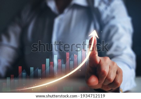 Businesswoman finger pointing arrow graph. Business development to success, profit and growing growth plan.	
