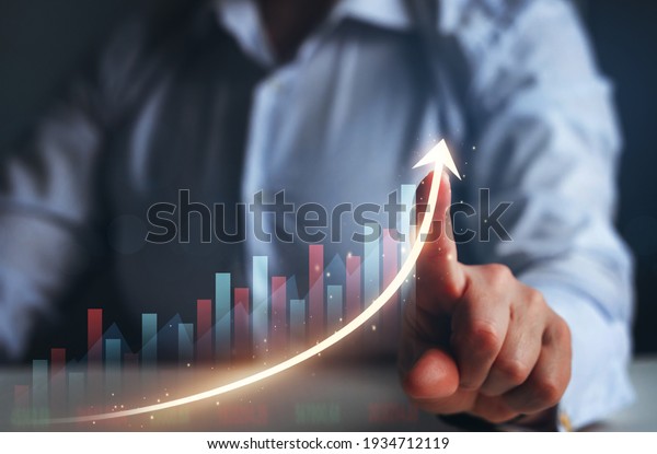 Businesswoman finger\
pointing arrow graph. Business development to success, profit and\
growing growth\
plan.	\
