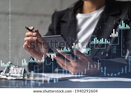 Businesswoman in formal wear is signing the contract to invest money in stock market. Internet trading and wealth management. Checking the details of transaction at smart phone. Forex