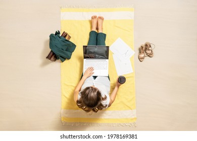 Businesswoman Freelancer In Office Suit Drinking Coffee Sitting  On Beach Towel Of Sand Beach And Working On Laptop With Graphics And Charts. Lunch Break. Aerial View 