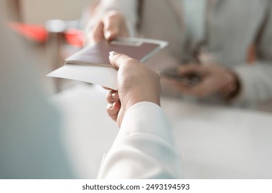 Businesswoman giving passport to airlines ground attendant or  immigration office at airport departure gate or check in counter. Travel and vacation concept - Powered by Shutterstock