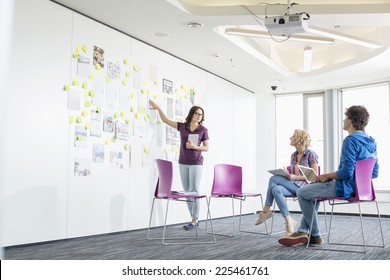 Businesswoman Giving Presentation To Colleagues In Creative Office Space