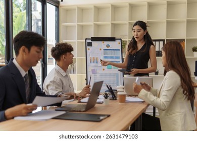Businesswoman giving a team presentation with charts and data visuals in a bright modern office. - Powered by Shutterstock - Get 15% off with code: PIKWIZARD15