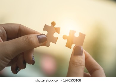 Businesswoman hand connecting jigsaw puzzle at outdoor. Business success and strategy concept - Shutterstock ID 1670533108