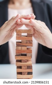 Businesswoman Hand Cover Wooden Block On The Tower. Business Planning, Risk Management, Solution, Insurance And Strategy Concepts