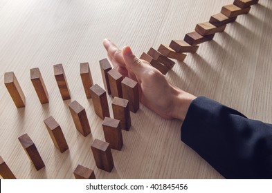 Businesswoman hand stopping the domino wooden effect concept for business. - Shutterstock ID 401845456