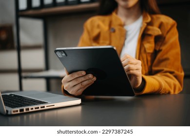 Businesswoman hand using laptop, tablet and smartphone in office. Digital marketing media mobile app and discussing plan new start up project. Finance task.
