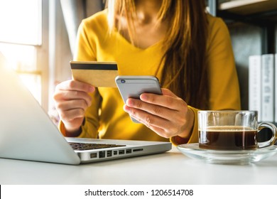businesswoman hand using smart phone, tablet payments and holding credit card online shopping, omni channel, digital tablet docking keyboard computer at office in sun light
