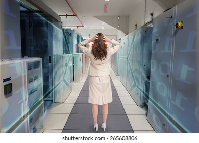 Businesswoman with hands on head standing back to camera against black background with shiny hexagons