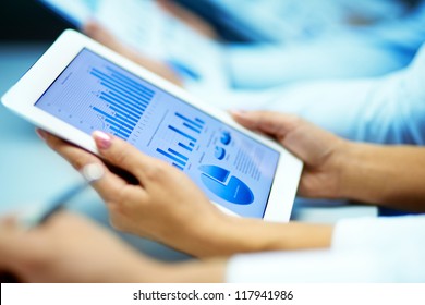 Businesswoman hands with touchpad while learning situation on the market - Powered by Shutterstock