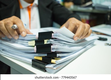 Businesswoman hands working on Stacks of documents files for finance in office. Business report papers or Piles of unfinished document achieves with black clip paper. Concept of Business Annual Report