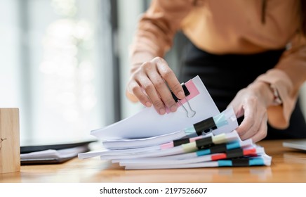 Businesswoman hands working in Stacks of paper files for searching and checking unfinished document achieves on folders papers at busy work desk office - Shutterstock ID 2197526607