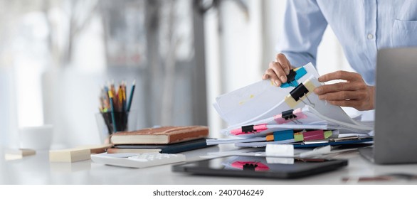 Businesswoman hands working in Stacks of paper files for searching and checking unfinished document achieves on folders papers at busy work desk office - Powered by Shutterstock