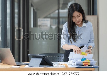 Businesswoman hands working in Stacks of paper files for searching and checking unfinished document achieves on folders papers