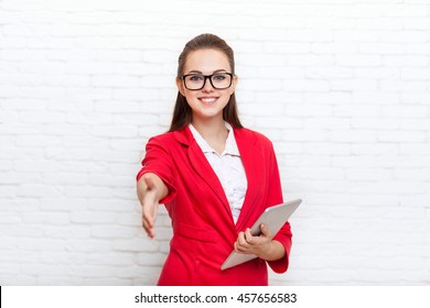 Businesswoman handshake, hold hand welcome gesture wear red jacket glasses business woman over office wall